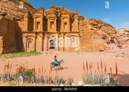 Beduinen auf Esel Vor Der kunstvoll geschnitzten Rock Grab als Kloster El Deir nabatäische Stadt Petra in Jordanien bekannt Stockfoto