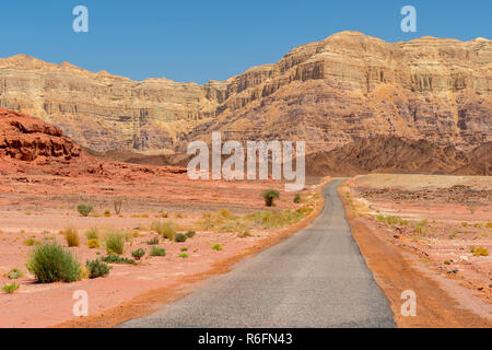 Einsame asphaltierte Straße durch die Berge und Wüste in Timna Nationalpark, Israel Stockfoto