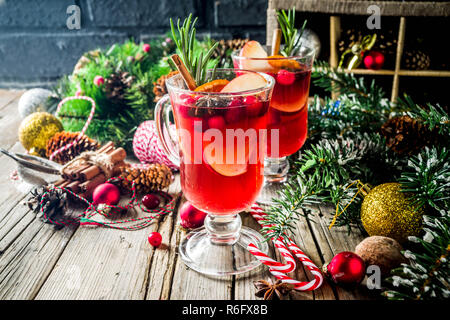 Traditionelle Weihnachten Glühwein, grog oder Pikanten sangria Cocktail, auf alten rustikalen Holztisch mit Weihnachtsschmuck und Fir Tree Branches cop Stockfoto