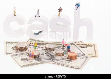 Miniatur Menschen auf Bargeld Holz- buchstaben und US-Banknoten Stockfoto