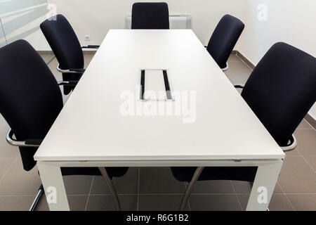 Kleiner Konferenzraum, weiße und schwarze Stühle Stockfoto