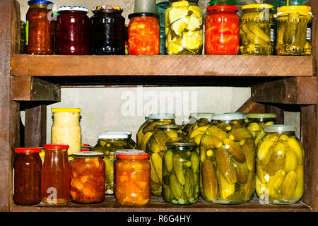 Gläser mit eingelegtem Gemüse, fruchtig, Kompott und Marmelade im Keller. Stockfoto