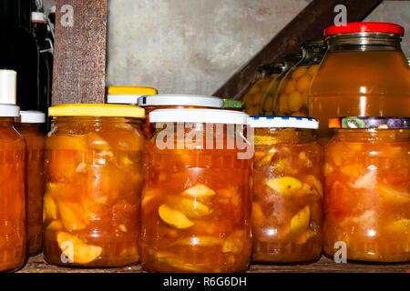 Gläser mit eingelegten Früchten, Beeren Kompotte und Apple Staus im Keller. Konserven Stockfoto