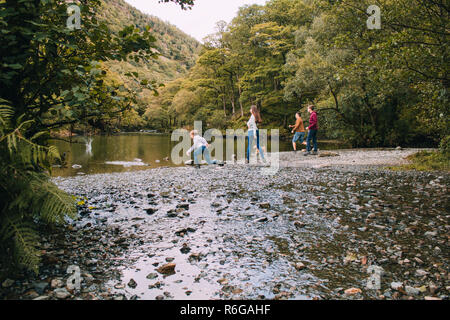 Familie Skimming Steine auf den Lake District Stockfoto