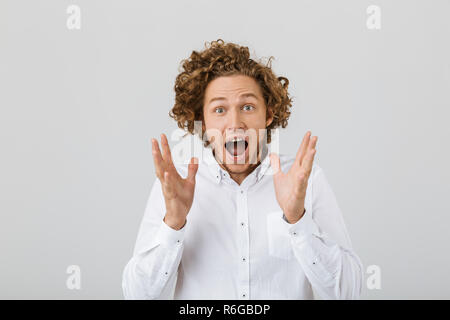 Porträt einer überrascht junger Mann mit lockigem Haar auf weißem Hintergrund, schreien Stockfoto