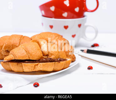 Croissants mit Schokolade auf eine weisse Platte Stockfoto