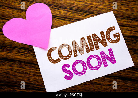 Konzeptionelle Hand schreiben Text angezeigt, die bald kommen. Konzept für die Zukunft auf haftnotiz Papier, Holz Holz Hintergrund. Mit rosa Herz bedeutet Liebe Anbetung. Stockfoto