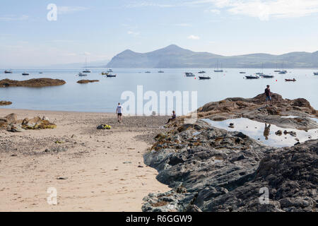 Besucher die Flut an Morfa Nefyn Strand auf der Halbinsel Llyn in Wales erkunden Stockfoto