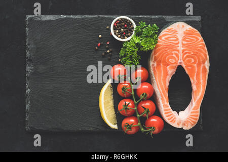 Lachs Steak und Gemüse auf schwarzem Schiefer Hintergrund. Ansicht von oben mit der Kopie Platz für Text, Menü, Rezept. Gesundes essen Hintergrund Stockfoto