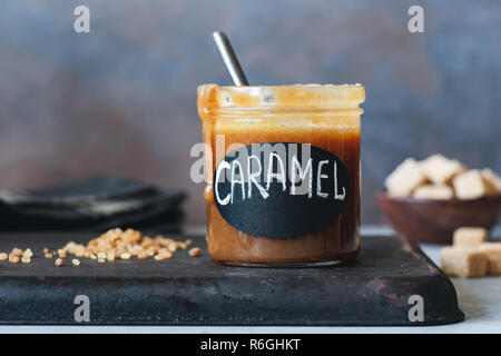 Hausgemachte gesalzen Karamell Sauce im Glas. Horizontale, ebene Oberfläche anzeigen Stockfoto