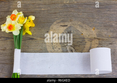 Auf einem alten Holzplatte mit einem Strauß Blumen Narzisse eingewickelt in white paper Tape. Kopieren Sie Platz. Freier Platz für Text Stockfoto