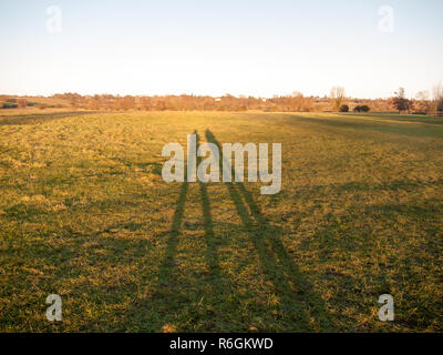 Zwei große Bein Silhouetten auf Gras Land Hintergrund Oberfläche Stockfoto