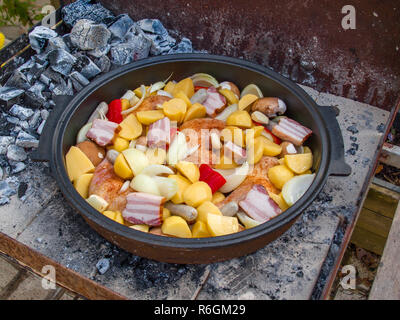 Dalmatiner Peka mit Fleisch und Gemüse gefüllt. Die vorbereiteten Zutaten erhält mit einem Guss Deckel geschlossen und mit Holzkohle und Wil für eine Stunde gekocht werden. Stockfoto