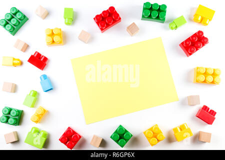 Bunte Würfel aus Holz und Kunststoff mit gelben leeres Papier Karte auf weißem Hintergrund. Stockfoto
