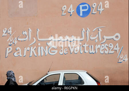 Marrakesch, Morocco-August 12,2017: Werbung für 24/24 Parkplatz an einer Wand mit Text in arabischer und französischer Sprache lackiert Stockfoto