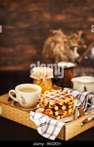 Frühstück mit belgischen Waffeln, Marmelade und Kaffee auf Fach, rustikale Hintergrund Stockfoto