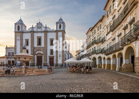 Praca do Giraldo und die Igreja de Santo Antao mit historischen Gebäuden und Cafés rund um den Platz bei Sonnenuntergang, Évora, Alentejo, Portugal, Europa Stockfoto