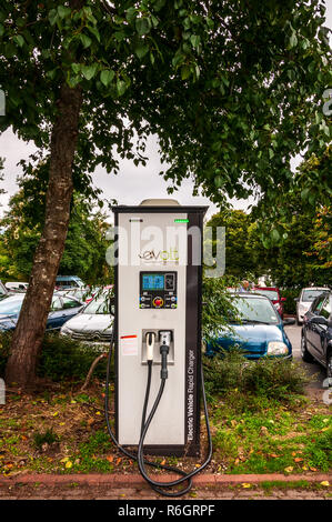 Ein großer rechteckiger lackiert Elektrofahrzeug Schnellladegerät mit zwei verschiedenen Anschlüssen und intuitive manuelle Kontrollen in einem öffentlichen Parkplatz entfernt montiert Stockfoto