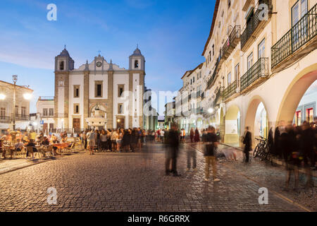 Praca do Giraldo und die Igreja de Santo Antao mit historischen Gebäuden und Café besetzt mit Studenten am Abend, Évora, Alentejo, Portugal, Europa Stockfoto