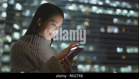 Frau sms auf Handy bei Nacht Stockfoto