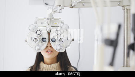 Asiatische Frau tun Auge Test in der Klinik Stockfoto