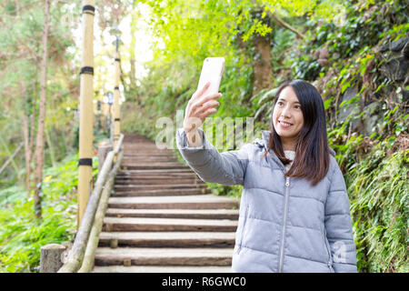 Frau unter Foto auf Handy in der Wanderweg Stockfoto