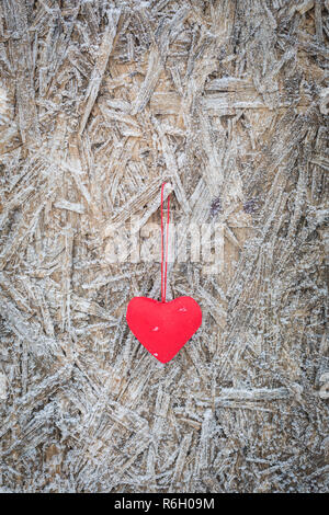 Red textile Herz hängen auf Eis bedeckt Hintergrund, Valentinstag gruss Konzept, getönt Stockfoto