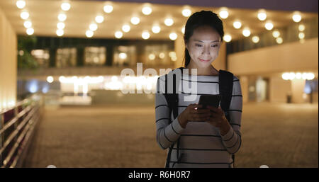 Frau Verwendung von Smart Phone in der Stadt bei Nacht Stockfoto