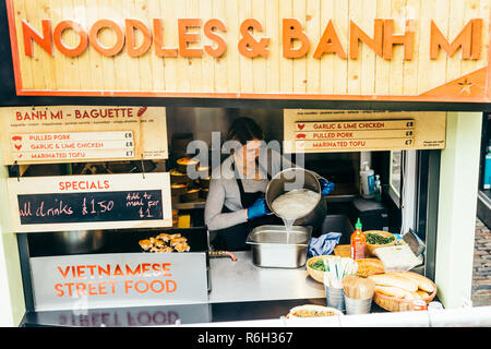 London/Großbritannien - 25. März 2018: Frau Zubereitung Nudeln in einem Stall in Camden Market in London. Stockfoto