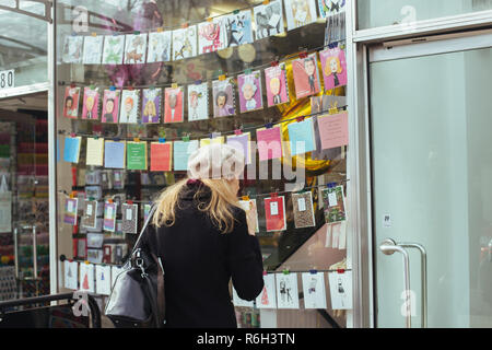 London/Großbritannien - 11. März 2018: Frau schaut durch das Fenster der-Büros, die eine Karte und Poster Shop auf der Holland Park Avenue in L Stockfoto