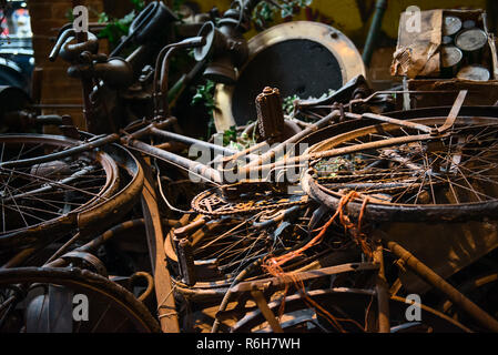 Alte rostige Fahrräder, Fahrräder, Retro vintage car Details und andere Elemente in ein Haufen Lügen und warten auf Ihre museum Restaurierung. Selektiver Fokus Stockfoto