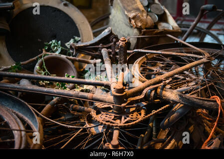 Alte rostige Fahrräder, Fahrräder, Retro vintage car Details und andere Elemente in ein Haufen Lügen und warten auf Ihre museum Restaurierung. Selektiver Fokus Stockfoto