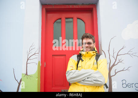 Reykjavik, Island - 12. Oktober 2017: glückliche Menschen. Aktiver Mann stand auf der Haus Tür. Tourist Agency. So glücklich wie eine Muschel. Reisen mehr glücklich erhalten, Stockfoto