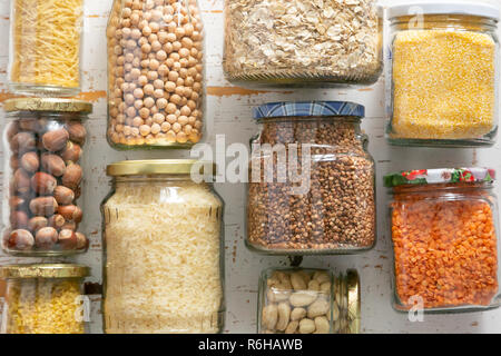 Verschiedene ungekochtem Getreide, Körner, Bohnen und Nudeln für gesundes Kochen in Gläsern Stockfoto