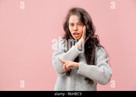 Geheimnis, Klatsch-Konzept. Junge Frau flüstert ein Geheimnis hinter ihrer Hand. Business woman am trendigen Pink Studio Hintergrund isoliert. Junge emotionale Frau. Menschliche Gefühle, Mimik Konzept. Stockfoto