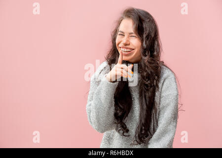 Geheimnis, Klatsch-Konzept. Junge Frau flüstert ein Geheimnis hinter ihrer Hand. Business woman am trendigen Pink Studio Hintergrund isoliert. Junge emotionale Frau. Menschliche Gefühle, Mimik Konzept. Stockfoto