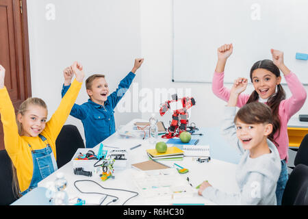 Glückliche Schüler jubeln und die Hände in der Luft während der stammzellen Lektion in der Klasse Stockfoto