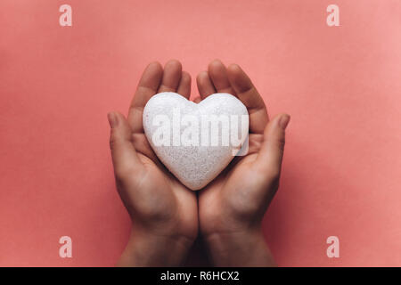 Das Mädchen hält ein Symbol in Form eines Herzens. Stockfoto
