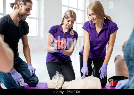 Medical instructor Holding Herzen Modell während der Erste Hilfe Kurse im Innenbereich Stockfoto