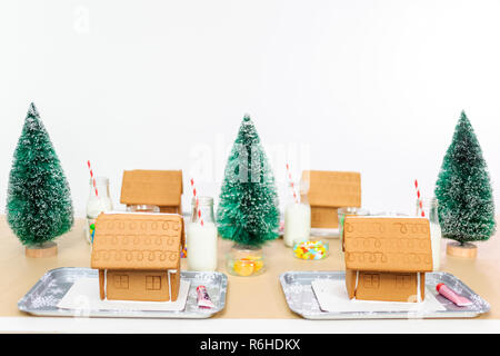 Kinder Partei kleine Lebkuchenhäuser mit Bonbons zu verzieren. Stockfoto
