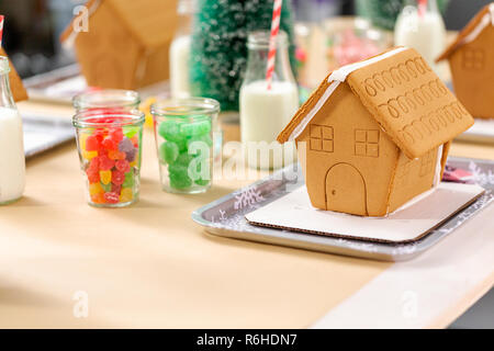 Kinder Partei kleine Lebkuchenhäuser mit Bonbons zu verzieren. Stockfoto
