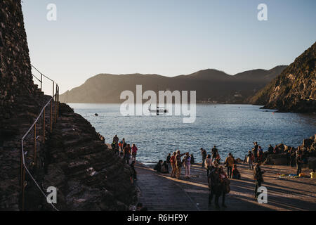 Vernazza, Italien - Oktober 30, 2016: Die Menschen warten auf ein Boot in Vernazza, Cinque Terre, bei Sonnenuntergang. Cinque Terre wurde als inbegriffen Stockfoto