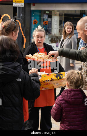 Kostenlose Würstchenrollen, die von einem Shop Assistant auf einem Tablett an Käufer in einer Straße in Leeds, West Yorkshire, England, Großbritannien, verteilt werden. Stockfoto