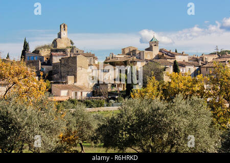 Blick auf ein altes Dorf im Luberon region, Südfrankreich. Alte Kirche und Häuser mit Bäumen und Sonnenschein. Stockfoto