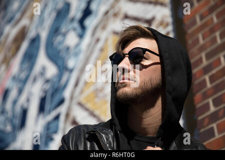 Portrait Headshots einer jungen schönen Attraktiv Modern Fashion kaukasischen Kerl Modellierung in der Nähe der Freien Kunst in der Stadt im Herbst Winter Stockfoto