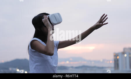 Frau verwendet eine virtuelle Realität Gläser auf dem Dach Stockfoto