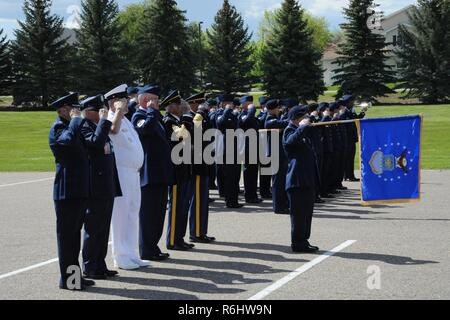 Aktiv-Flieger und pensionierten militärischen Mitglieder begrüssen, während die Hähne während ein Rentner Wertschätzung retreat Zeremonie am Medal of Honor Park an der Malmstrom Air Force Base gespielt wird, Mont. Die Veranstaltung war Teil der jährlichen Rentner Anerkennung Tag der Flügel 19. Mai 2017 statt. Stockfoto