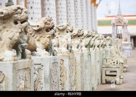 Foo dog Statuen aufgereiht in einer abnehmenden Perspektive in der Ordination Halle in Bangkok, Thailand. Stockfoto
