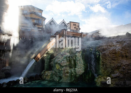 Heißer Dampf steigt aus den Yubatake-Feld heißes Wasser, Feder in der Mitte des Kusatsu Town, Japan. Stockfoto