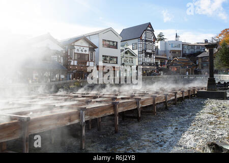 Heißer Dampf steigt aus den Yubatake-Feld heißes Wasser, Feder in der Mitte des Kusatsu Town, Japan. Stockfoto